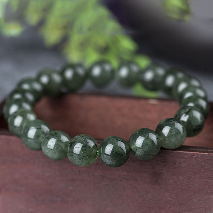 Grünes Kristall Armband Wohlstand & Segen auf braunem Tuch Nahaufnahme