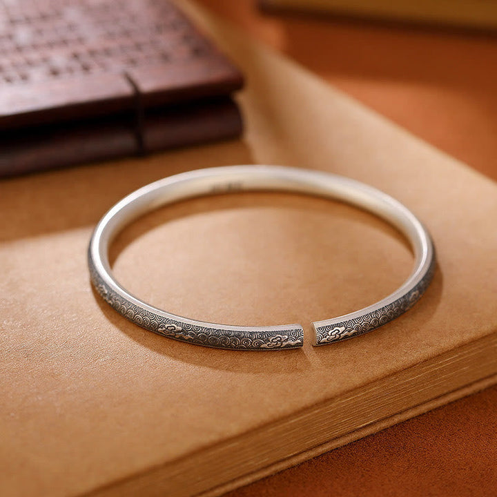 Silbernes Armband 925 mit Gravur auf Holztisch elegant platziert.