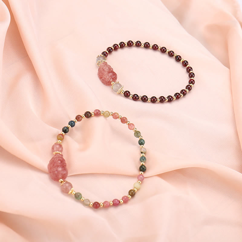 Zwei Armbänder mit Erdbeerquarz und Mondstein Perlen elegant präsentiert.