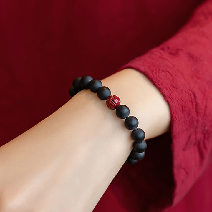 Armband Zinnober Lotus – Heilung schwarze Perlen Handgelenk getragen