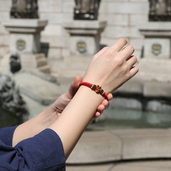 Rotes Armband mit goldenen Perlen am Handgelenk getragen elegant
