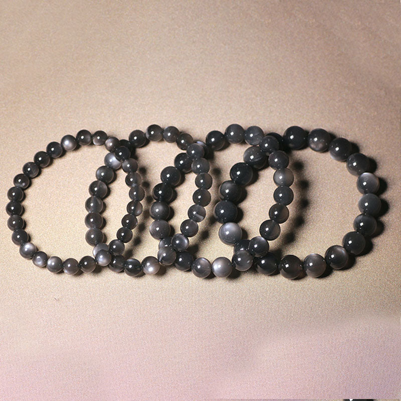 Fünf schwarze Mondstein Armbänder nebeneinander auf neutralem Hintergrund angeordnet