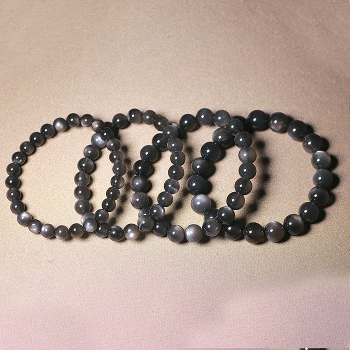 Fünf schwarze Mondstein Armbänder nebeneinander auf neutralem Hintergrund angeordnet