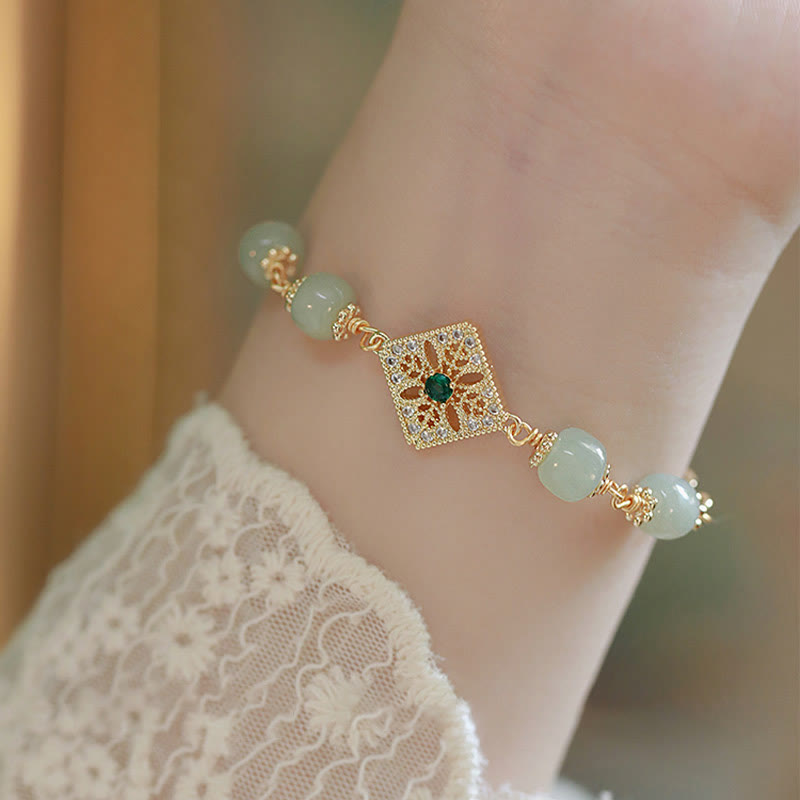 Hetian Jade Armband mit goldener Blütenfiligran-Verschluss elegant am Handgelenk