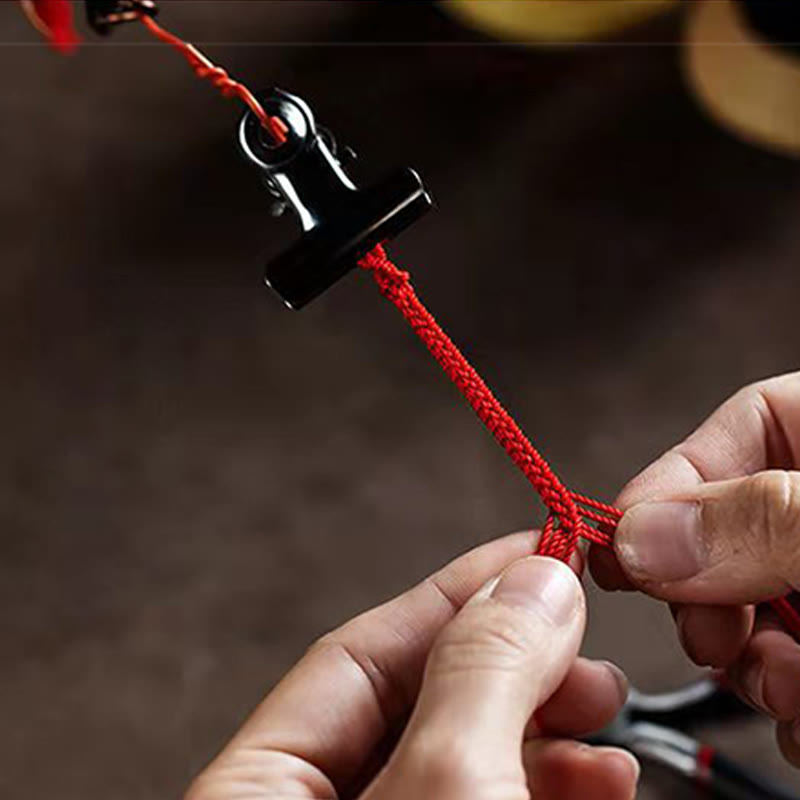 Armband Zinnober Pixiu am Handgelenk, rotes Seil, schwarze Verschlüsse