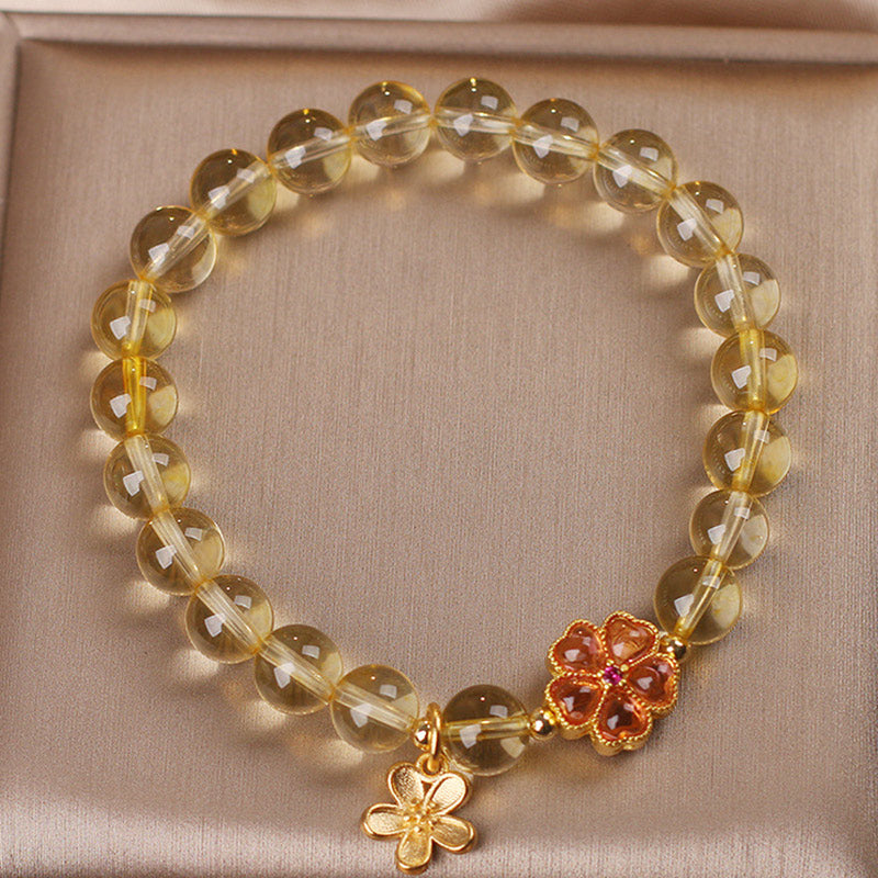 Armband Citrin mit goldenen Blütenanhängern elastisch getragen