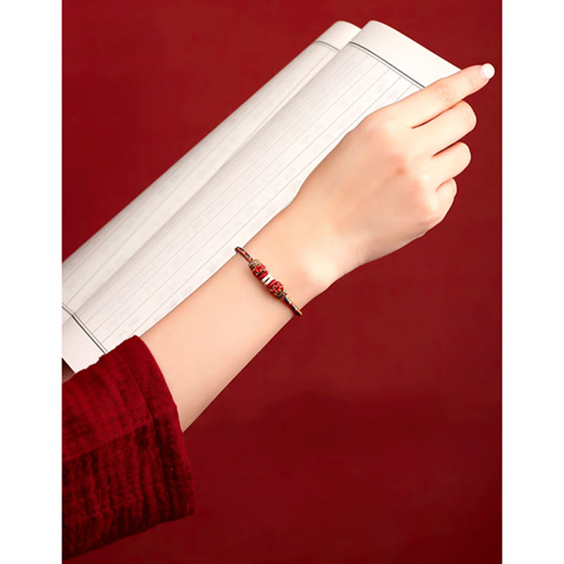 Armband Geflochtenes Rotes Schnur Karma am Handgelenk mit Notizbuch getragen rot