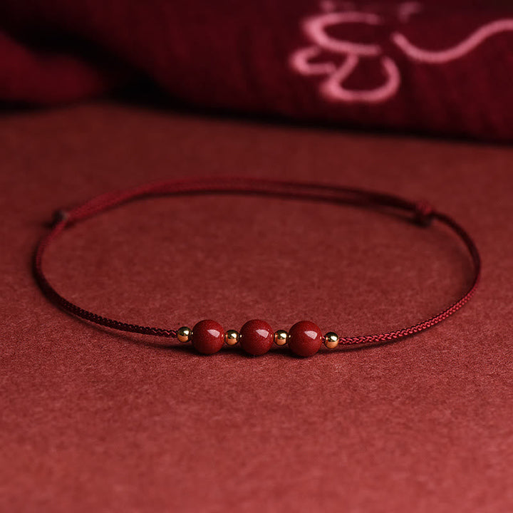 Zinnober Armband mit roten Perlen auf rotem Hintergrund, Flachaufnahme, Glück & Segen