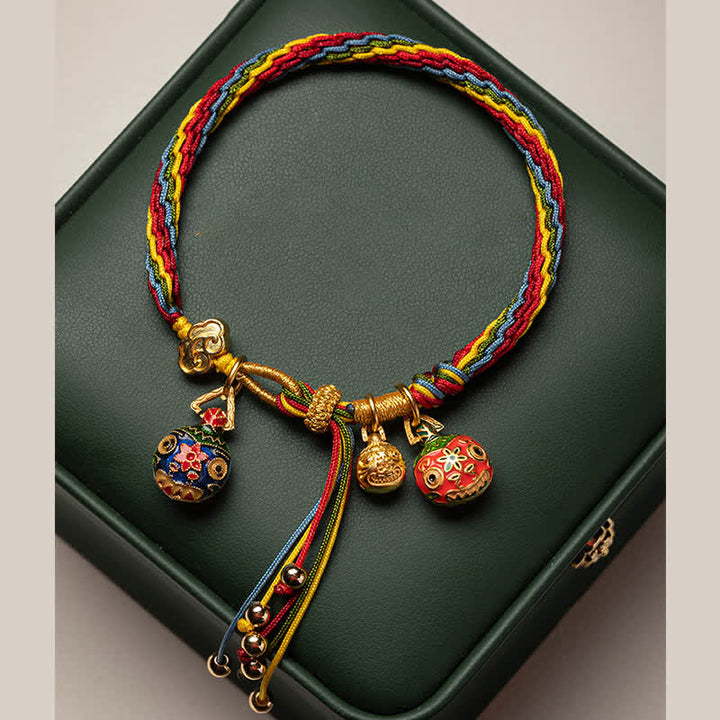 Buntes Armband mit goldenem Verschluss und roten Glückskugeln Anhängern.
