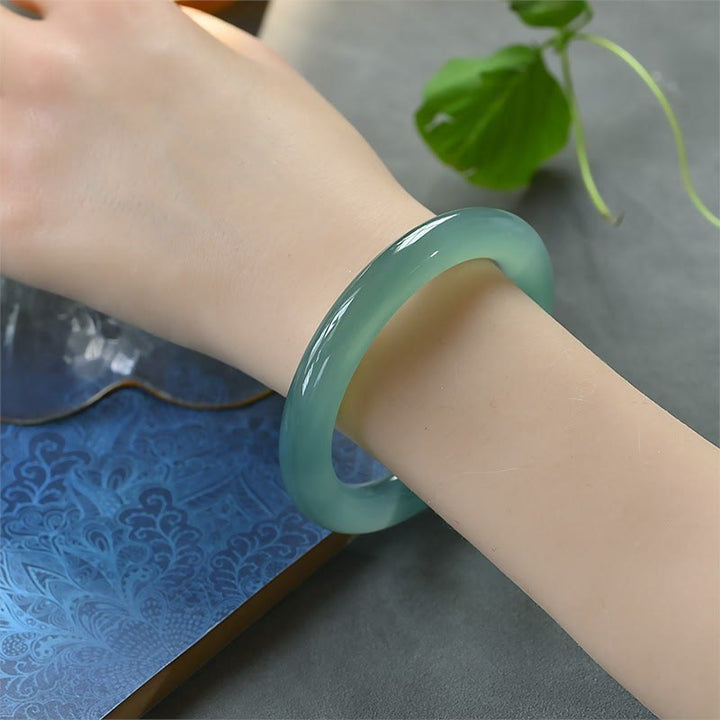 Grüner Chalcedon Armband am Handgelenk getragen, polierter Naturstein Armreif