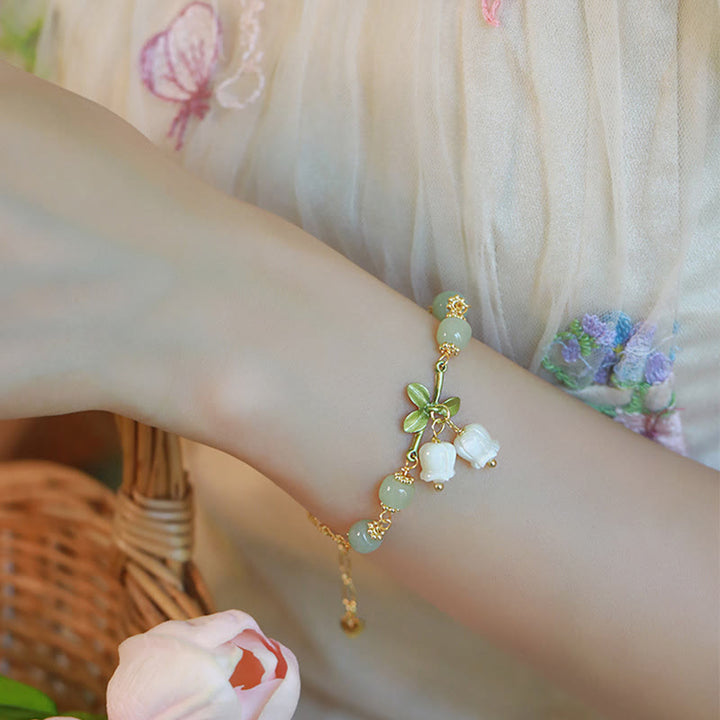 Armband Grüne Jade – Wohlstand mit weißen Perlen elegant am Handgelenk getragen