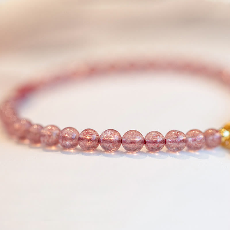 Erdbeerquarz Armband mit glänzenden rosa Perlen elegant am Handgelenk getragen