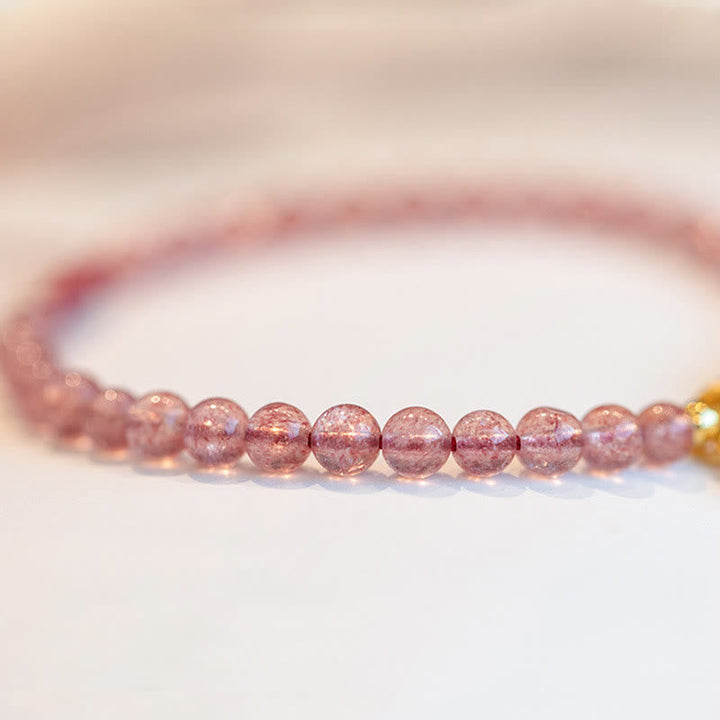 Erdbeerquarz Armband mit glänzenden rosa Perlen elegant am Handgelenk getragen
