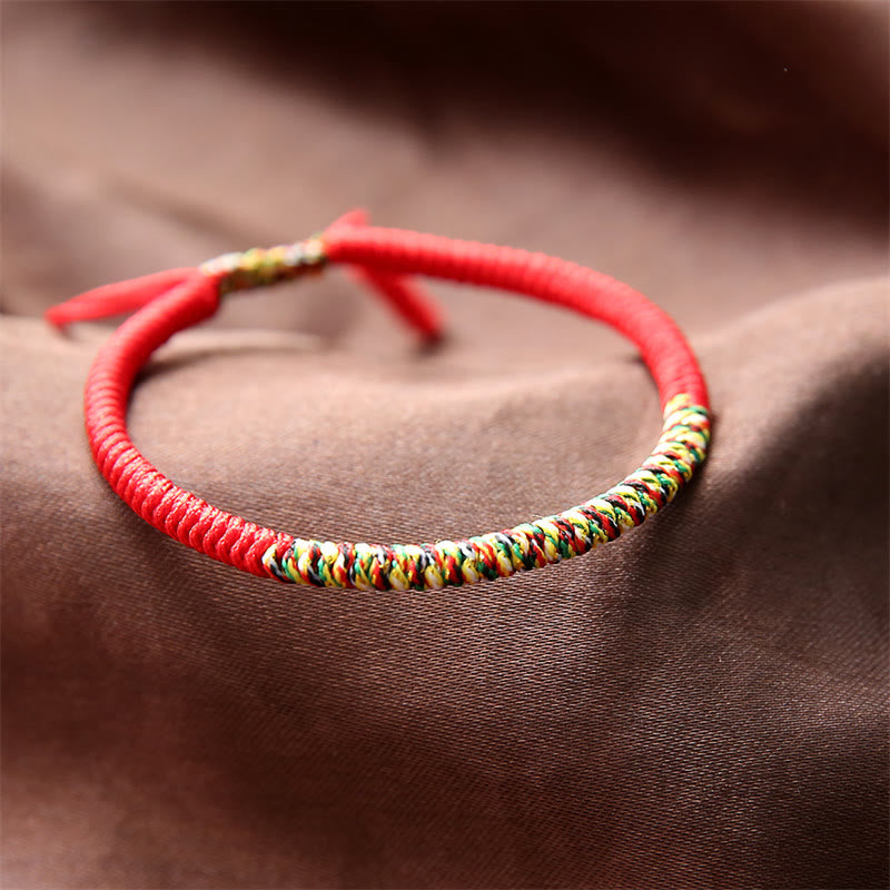 Rotes Armband – Glück & Stärke mit bunten Fäden elastisch getragen
