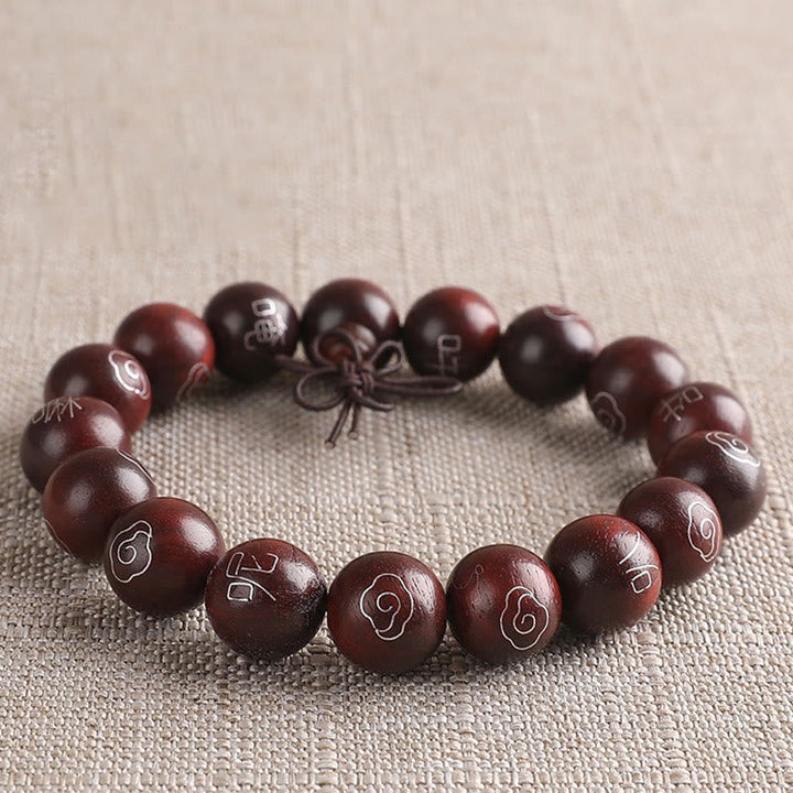 Sandelholz Armband mit Om-Symbolen auf neutralem Leinenhintergrund elegant präsentiert.