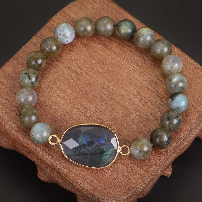 Armband Labradorit Mondstein mit facettiertem Anhänger auf Holz Flat Lay