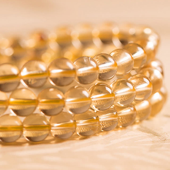 Citrin Mala Armband mit goldenen runden Perlen elastisch getragen