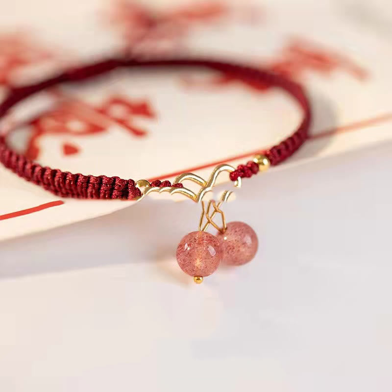 Rotes Armband Erdbeerquarz mit goldenem Anhänger elegant getragen
