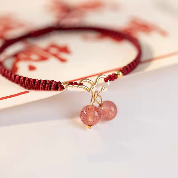 Rotes Armband Erdbeerquarz mit goldenem Anhänger elegant getragen