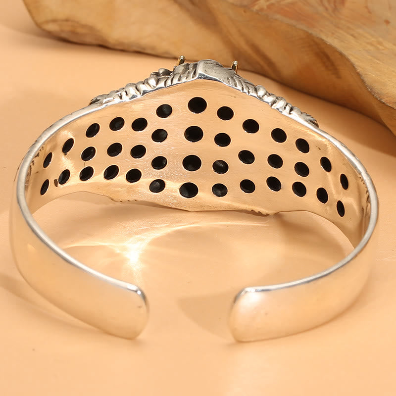 Silbernes Armband mit durchbrochenen Mustern elegant präsentiert.