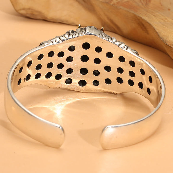 Silbernes Armband mit durchbrochenen Mustern elegant präsentiert.