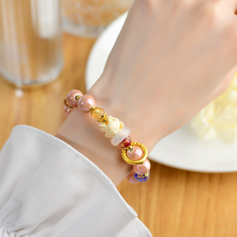 Perlenarmband mit Citrin und Rosenquarz am Handgelenk getragen elegant