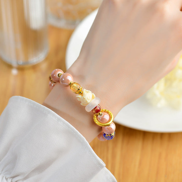 Perlenarmband mit Citrin und Rosenquarz am Handgelenk getragen elegant