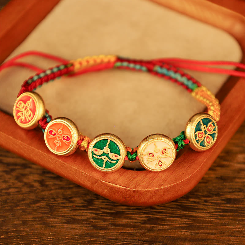 Armband Five Five – Glück & Wohlstand mit goldenen Medallions auf Holz.