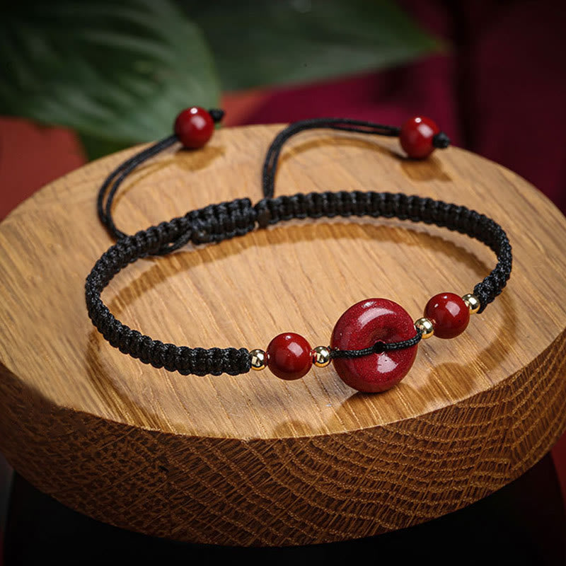 Armband Zinnober – Frieden & Segen mit schwarzem Makramee und roten Perlen.