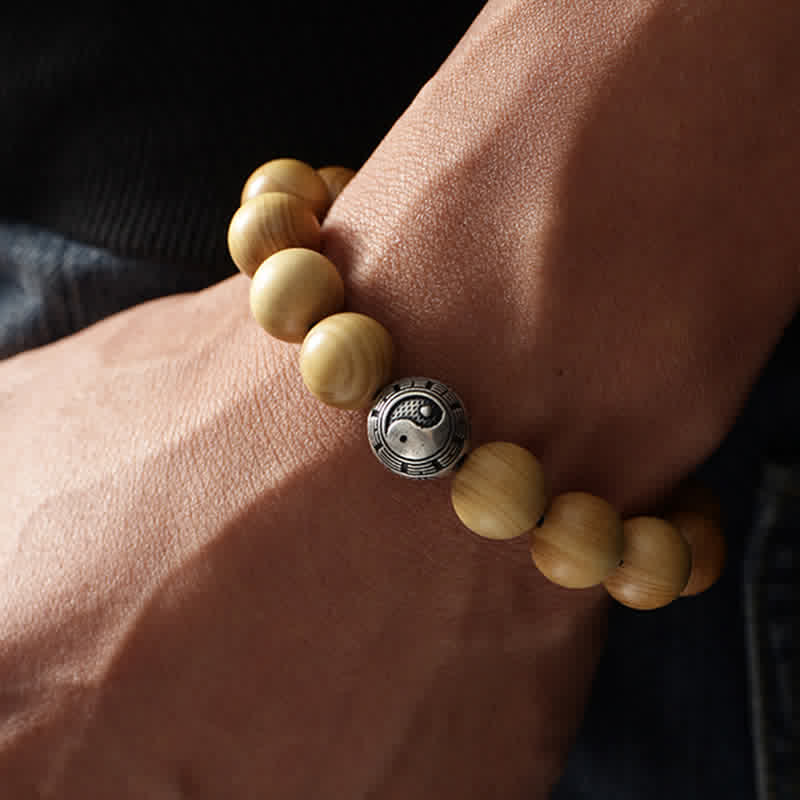 Holzperlen Armband mit Yin Yang Zinnober Anhänger am Handgelenk getragen