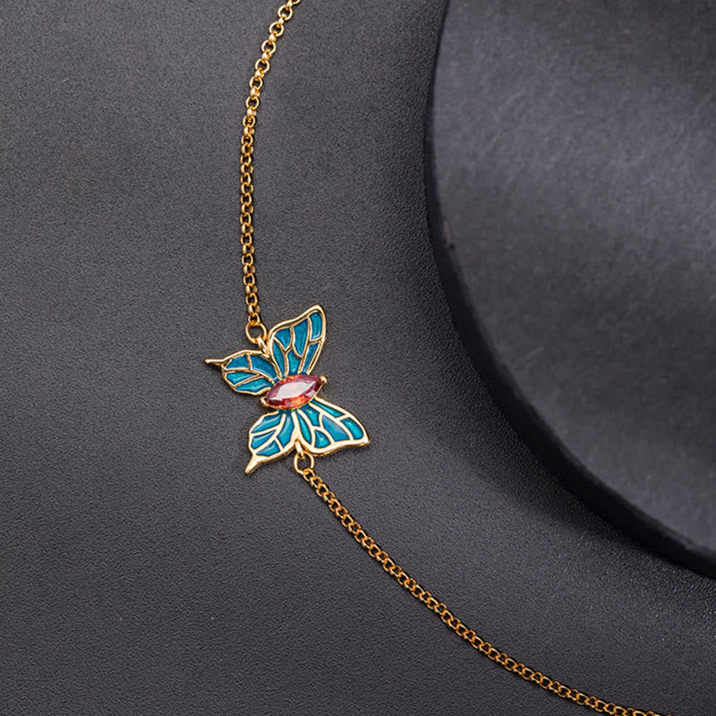 Goldenes Schmetterlings-Armband mit blauen und rosa Emaille-Details elegantes Design.