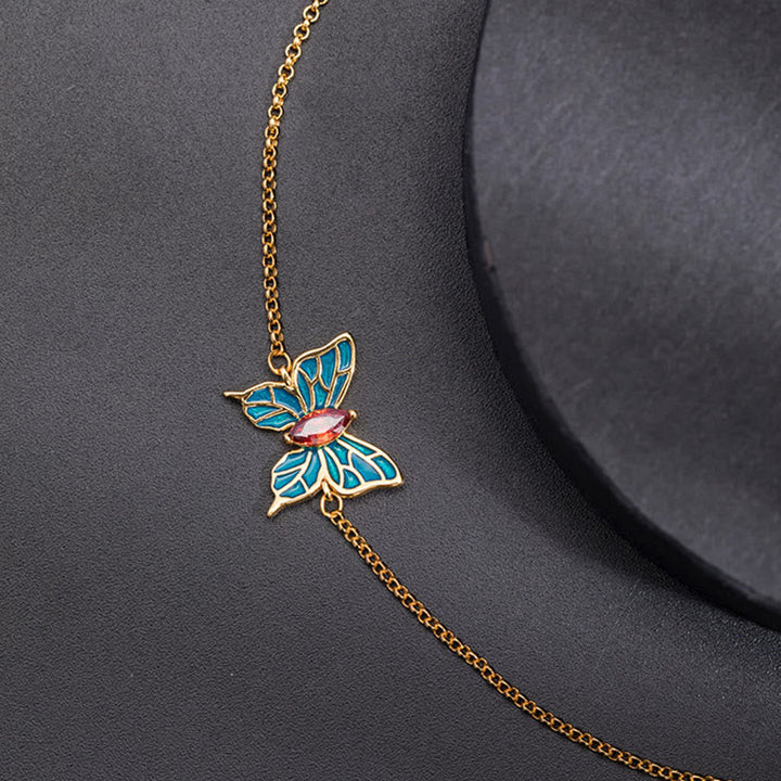 Goldenes Schmetterlings-Armband mit blauen und rosa Emaille-Details elegantes Design.