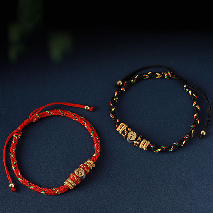 Rotes und schwarzes Armband mit goldenen chinesischen Tierkreis Glücksanhängern.
