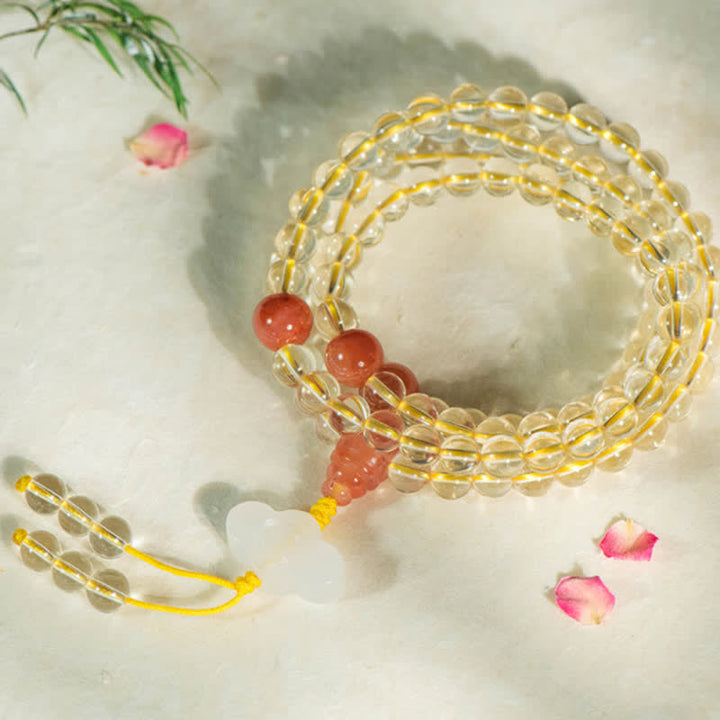 Citrin Mala Armband mit roten Perlen auf weißem Hintergrund.