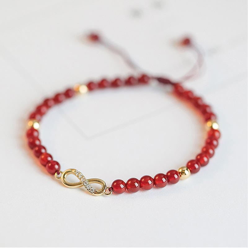 Armband Roter Achat mit Kleeblatt Charm elegant am Handgelenk getragen