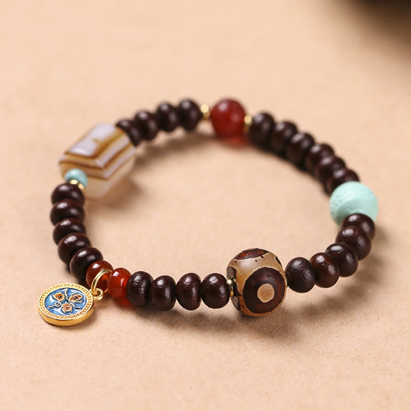 Bodhi Armband mit dunklen Holzperlen und roten Akzenten, Wohlstand & Energie.