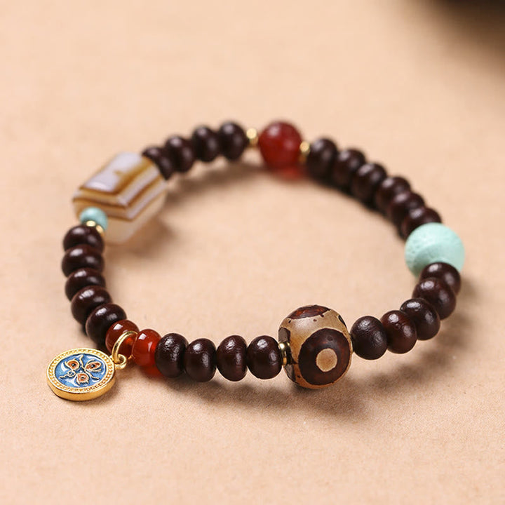 Bodhi Armband mit dunklen Holzperlen und roten Akzenten, Wohlstand & Energie.