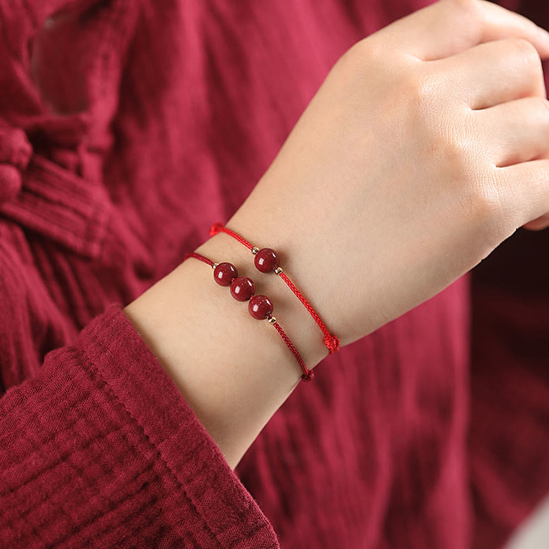 Armband Zinnober – Glück & Segen am Handgelenk, rote Perlen elastisch getragen