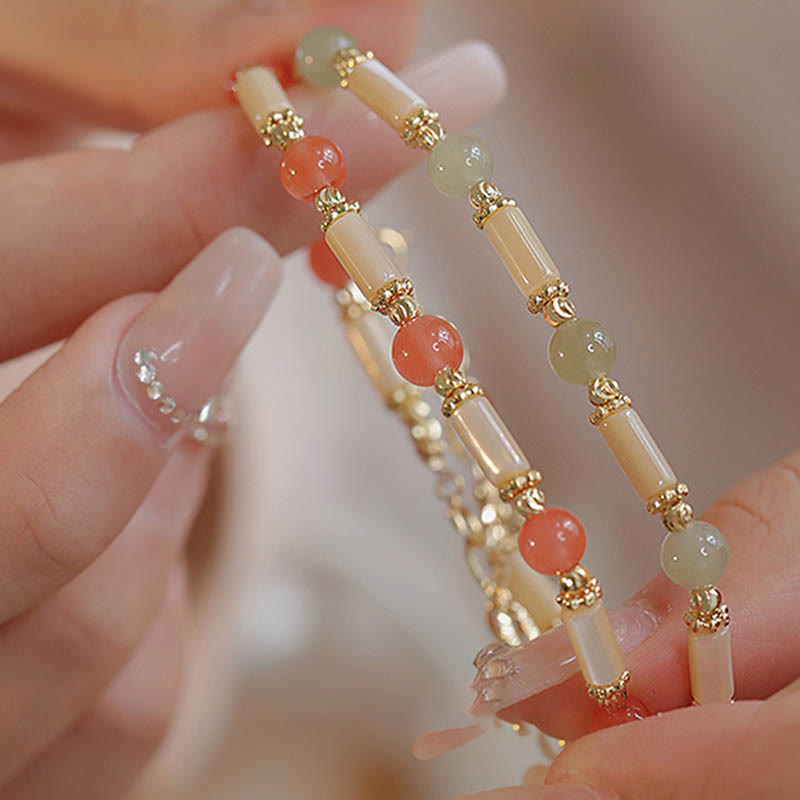 Armband Roter Achat Jade – Segen am Handgelenk mit goldenen Perlen getragen