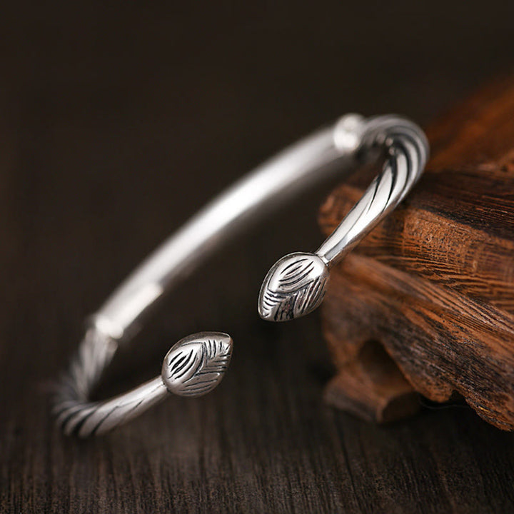 Silbernes Armband mit Blattmotiv auf Holz Nahaufnahme Schmuck