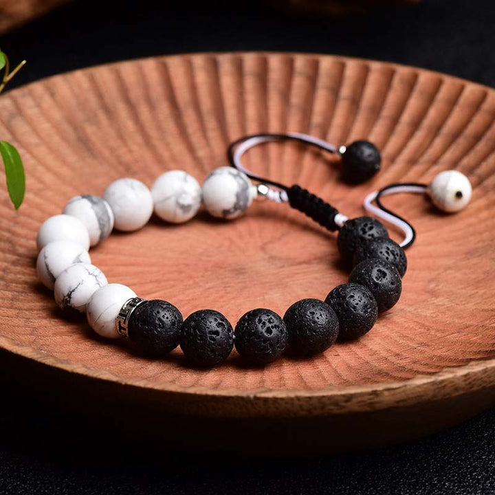 Armband Lavastein Yin Yang Schutz schwarze weiße Perlen Holzteller Flatlays