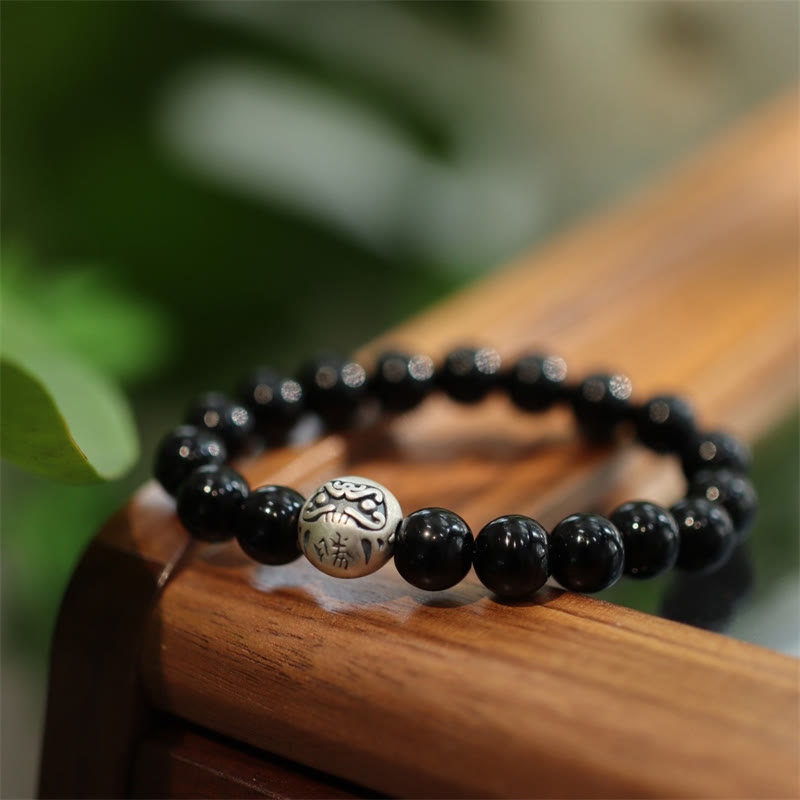 Schwarzes Onyx Armband mit Silber Perle auf Holz Natur