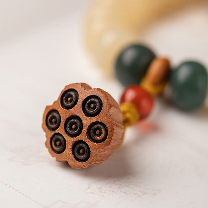 Bodhi Lotus Armband mit Perlen und Holzanhänger auf weißem Hintergrund.