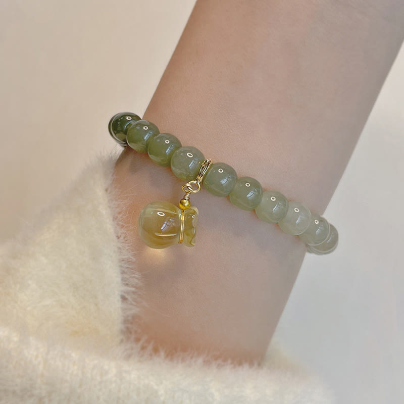 Jade Armband am Handgelenk mit goldenem Anhänger Naturstein