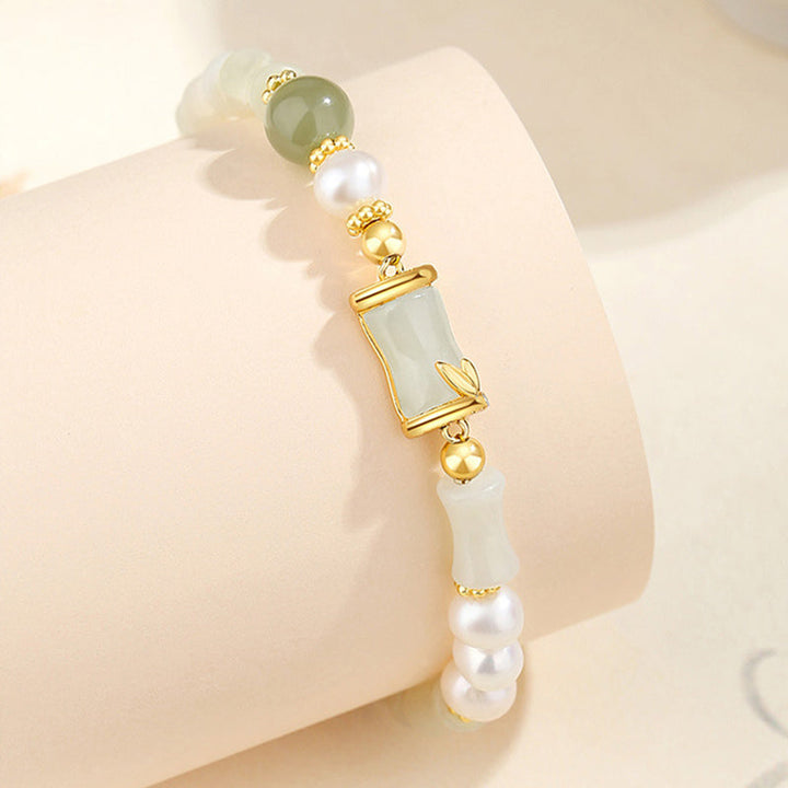 Elegantes Armband mit Jade, Perlen und goldenen Akzenten am Handgelenk.