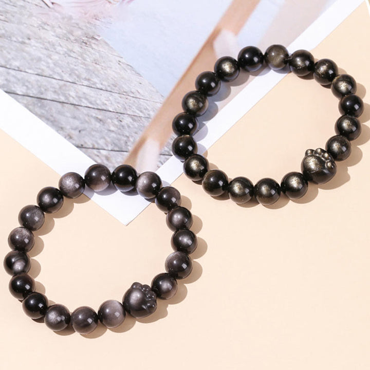 Schwarze Obsidian Armbänder mit silbernen Perlen elegant arrangiert.