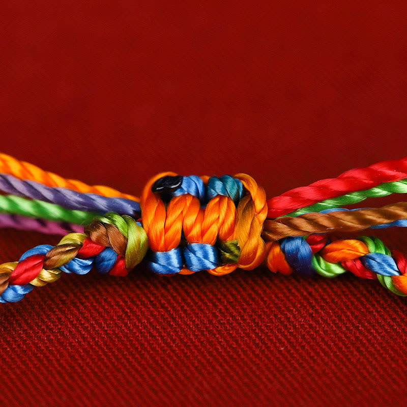 Buntes Seil Armband Glück Knoten rotes Textil Hintergrund Nahaufnahme