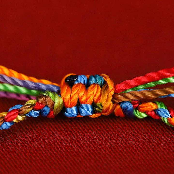 Buntes Seil Armband Glück Knoten rotes Textil Hintergrund Nahaufnahme