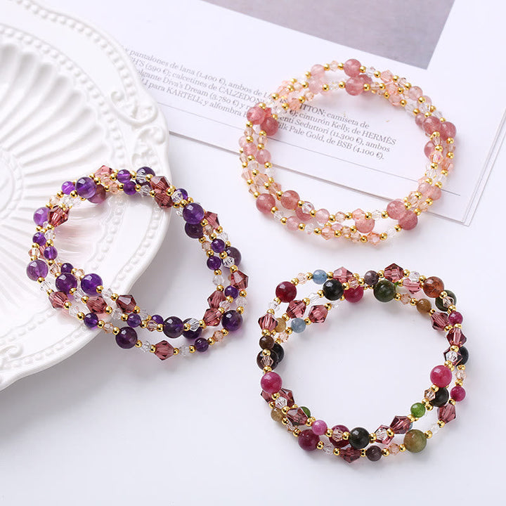Drei bunte Armbänder mit Edelsteinen und Perlmutt flach arrangiert präsentiert.