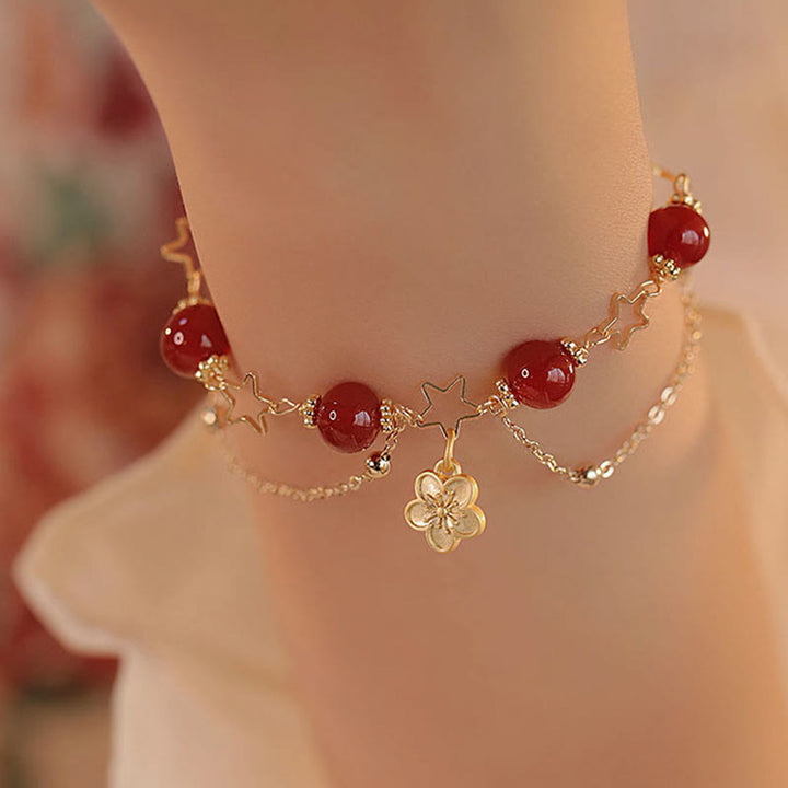 Armband Roter Achat Stern – Ruhe am Handgelenk mit goldenen Akzenten getragen